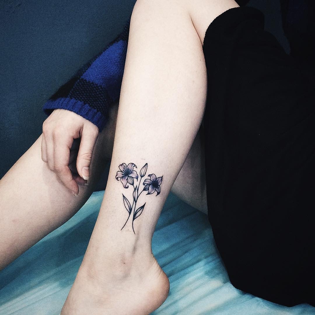 Hình xăm đóa hoa xanh đen ở cổ chân