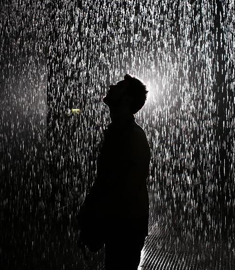 Hình ảnh một chàng trai đứng trong bóng tối với cơn mưa buồn