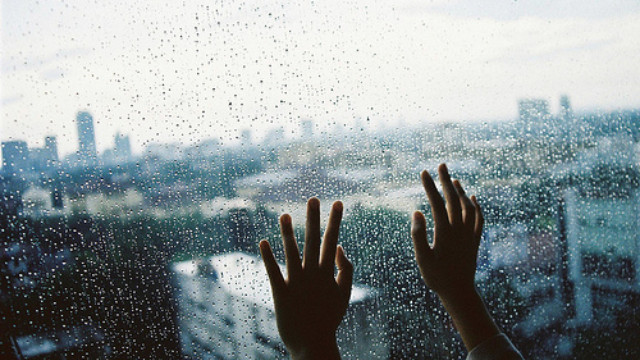 Hình ảnh mưa buồn hai bàn tay đặt lên kính