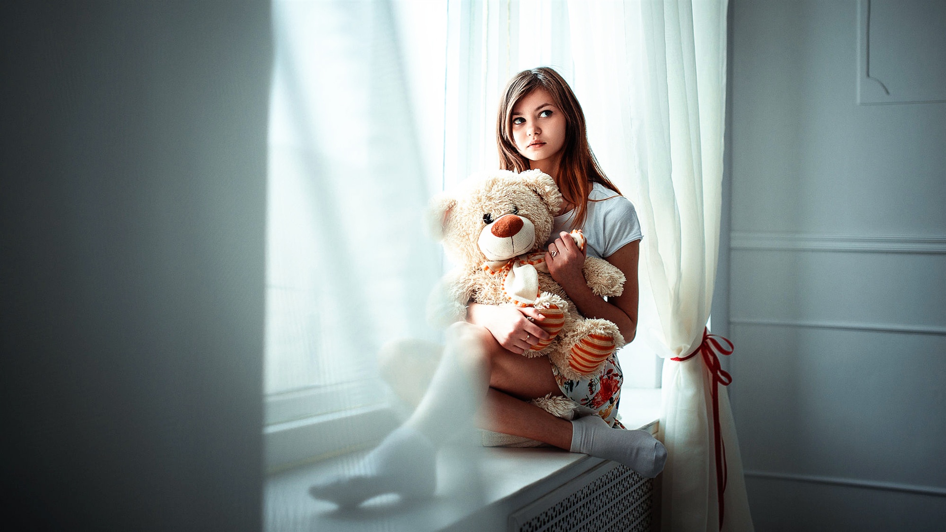 Hình ảnh cô gái có tâm trạng ngồi ôm gấu bông