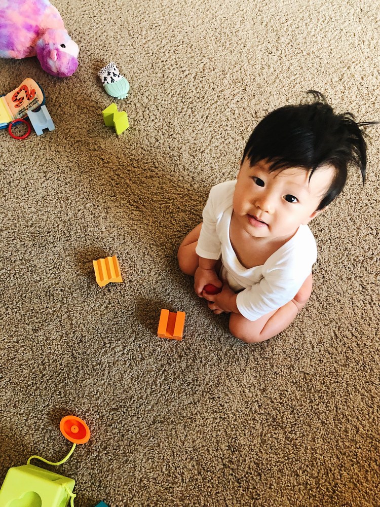 Hình ảnh đứa bé ngồi chơi đồ chơi đáng yêu